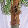 Close-up of a large fake palm tree with lush green foliage