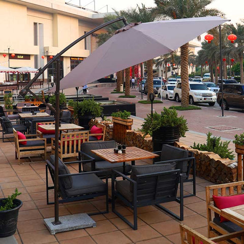 Cantilever hanging umbrella providing shade in a garden setting